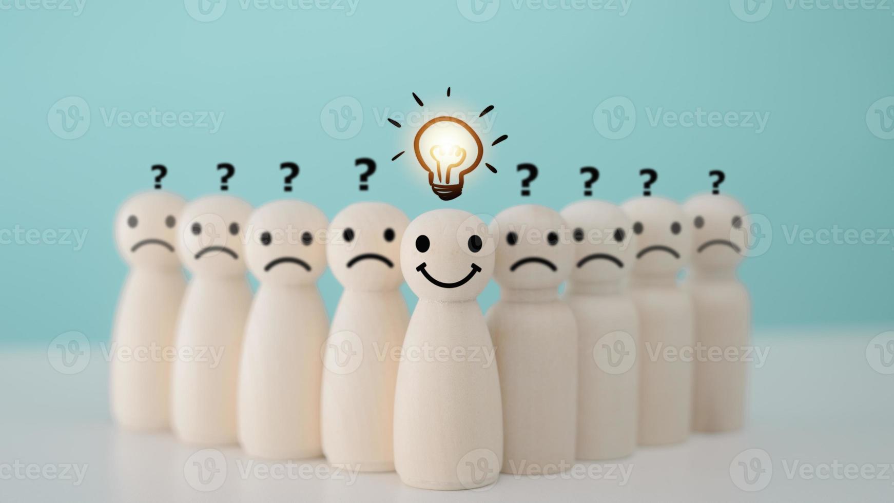 Smiley wooden human with light bulb and others human with question mark for creative thinking and problem solving solution concept. photo