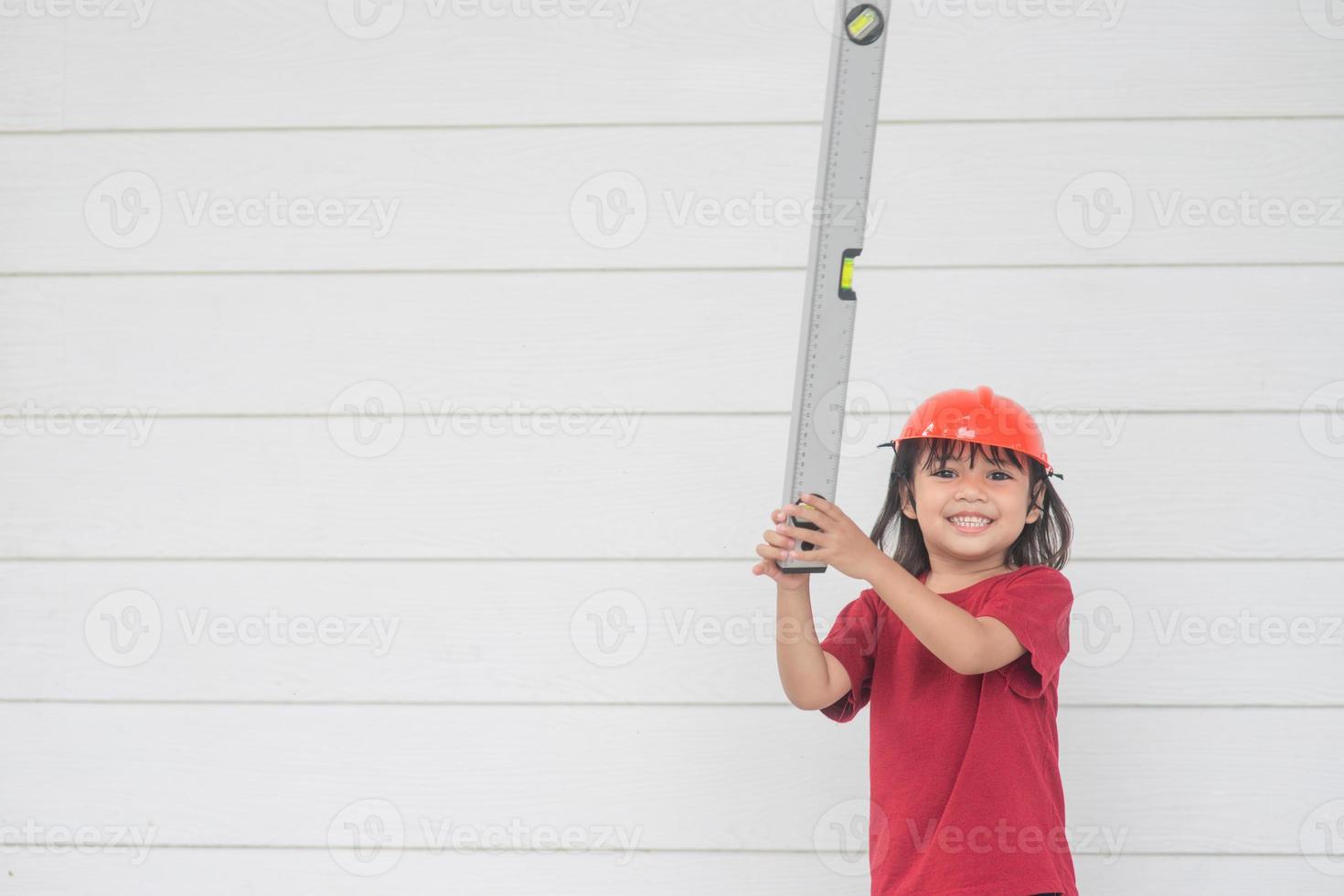 Asian girl children playing as an engineer helmet photo