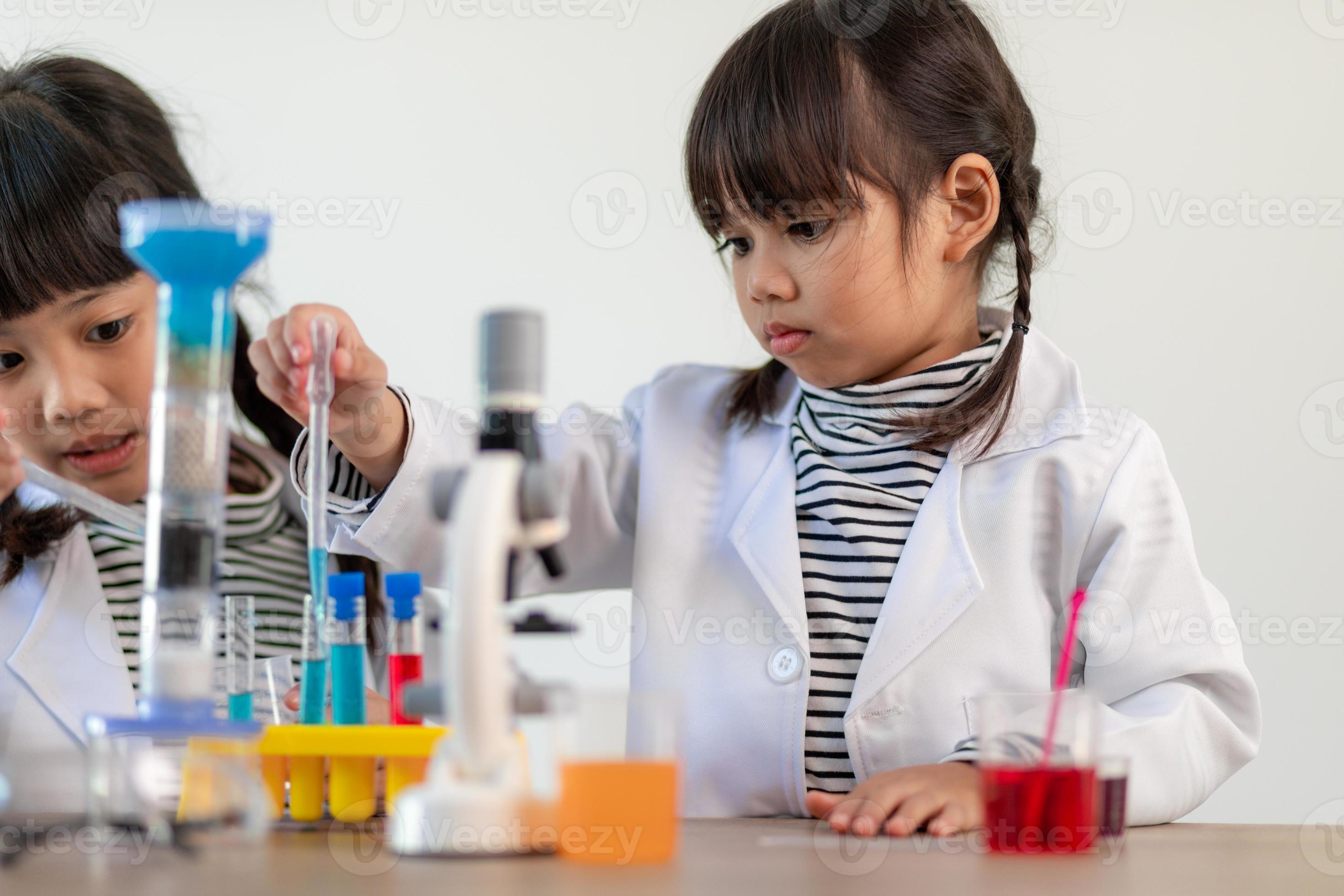 education, science, chemistry and children concept kids or students with test tube making
