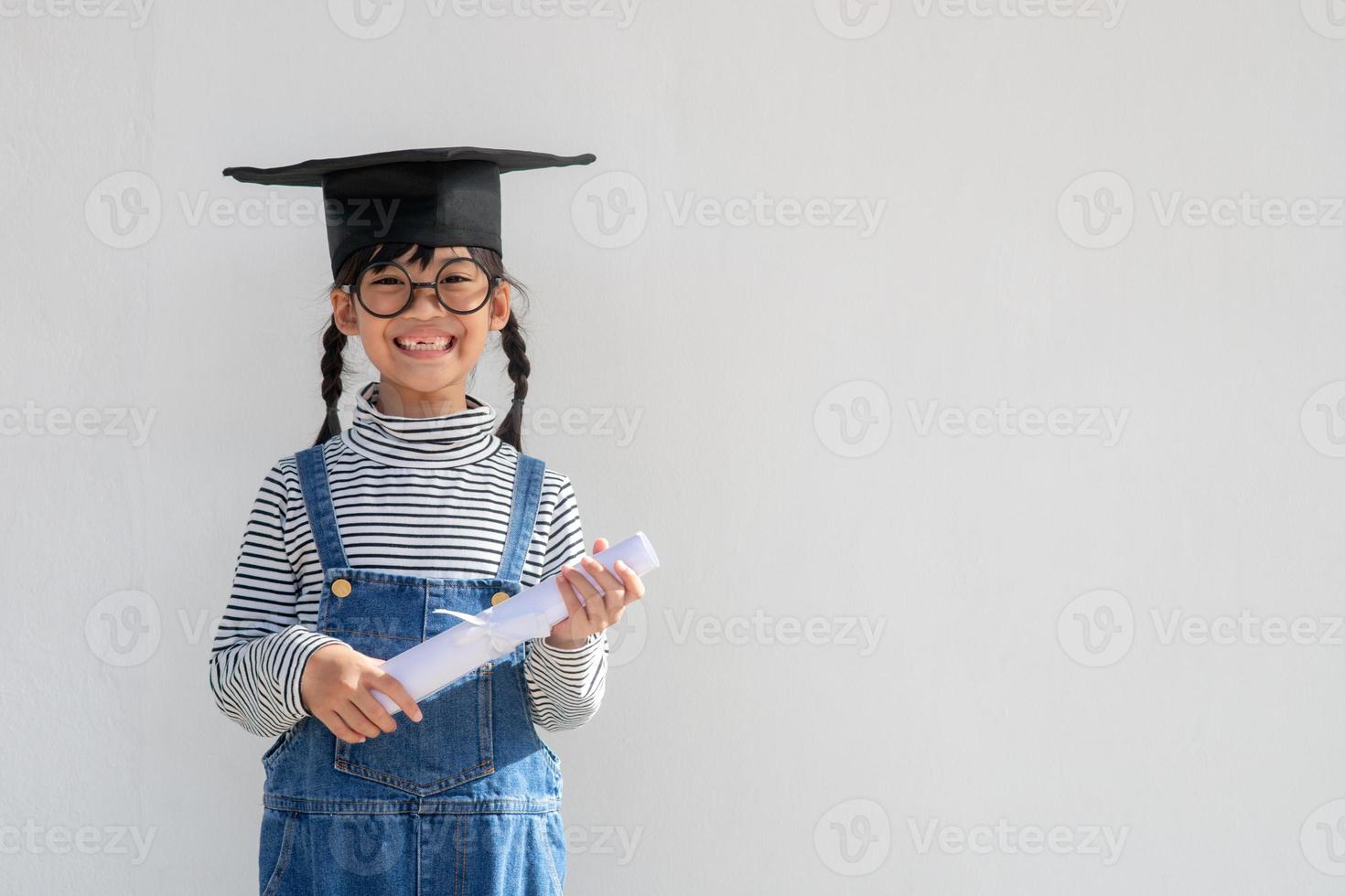 Happy Asian school kid graduate in graduation cap photo