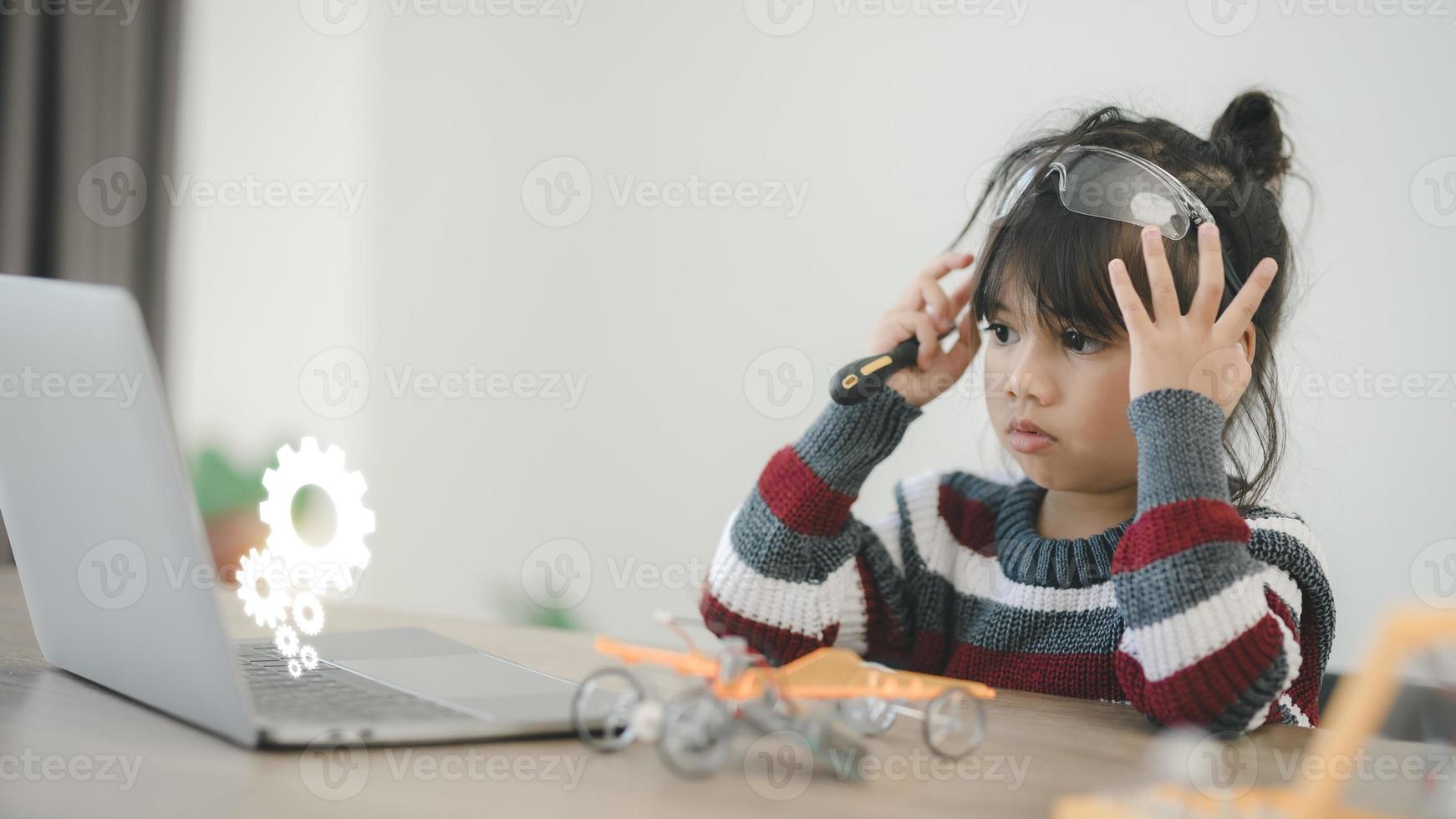 Inventive kid constructing robot cars at home photo