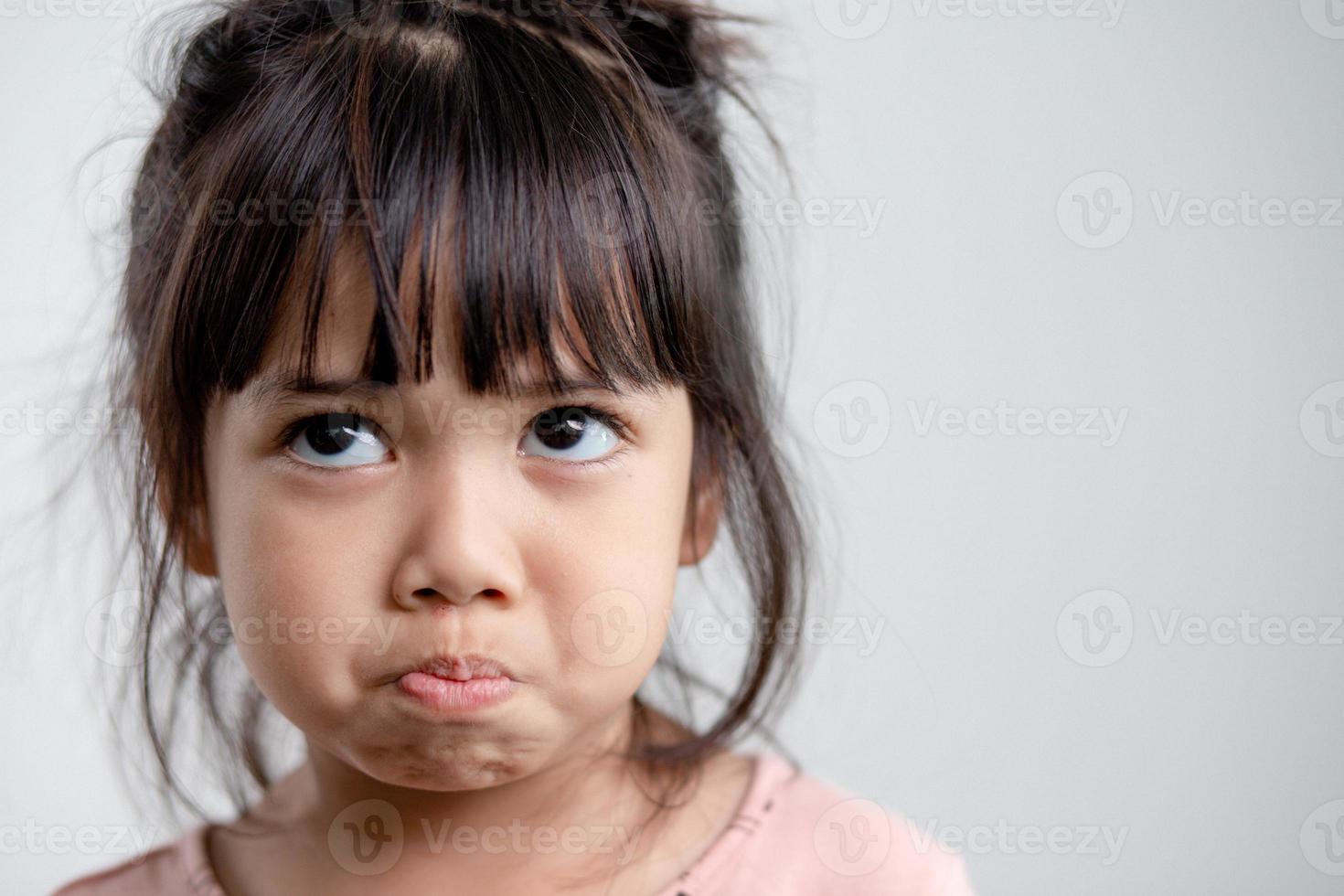 Angry little girl over white background, sign and gesture concept photo