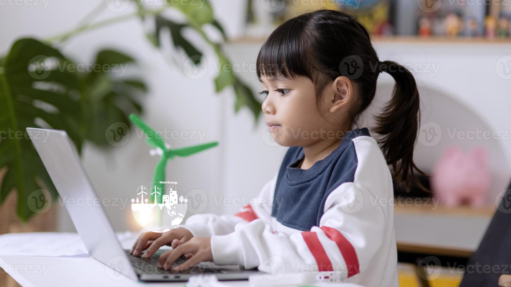 renewable energy, science, and technology concept - happy children with laptop computers, wind energy hologram,s and wind turbine models and icons. photo