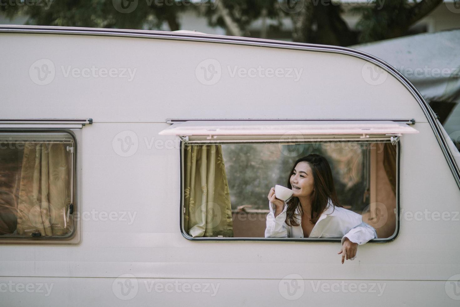 morning, coziness, winter and people concept - close up of happy young woman with cup of coffee or cocoa drink in bed photo