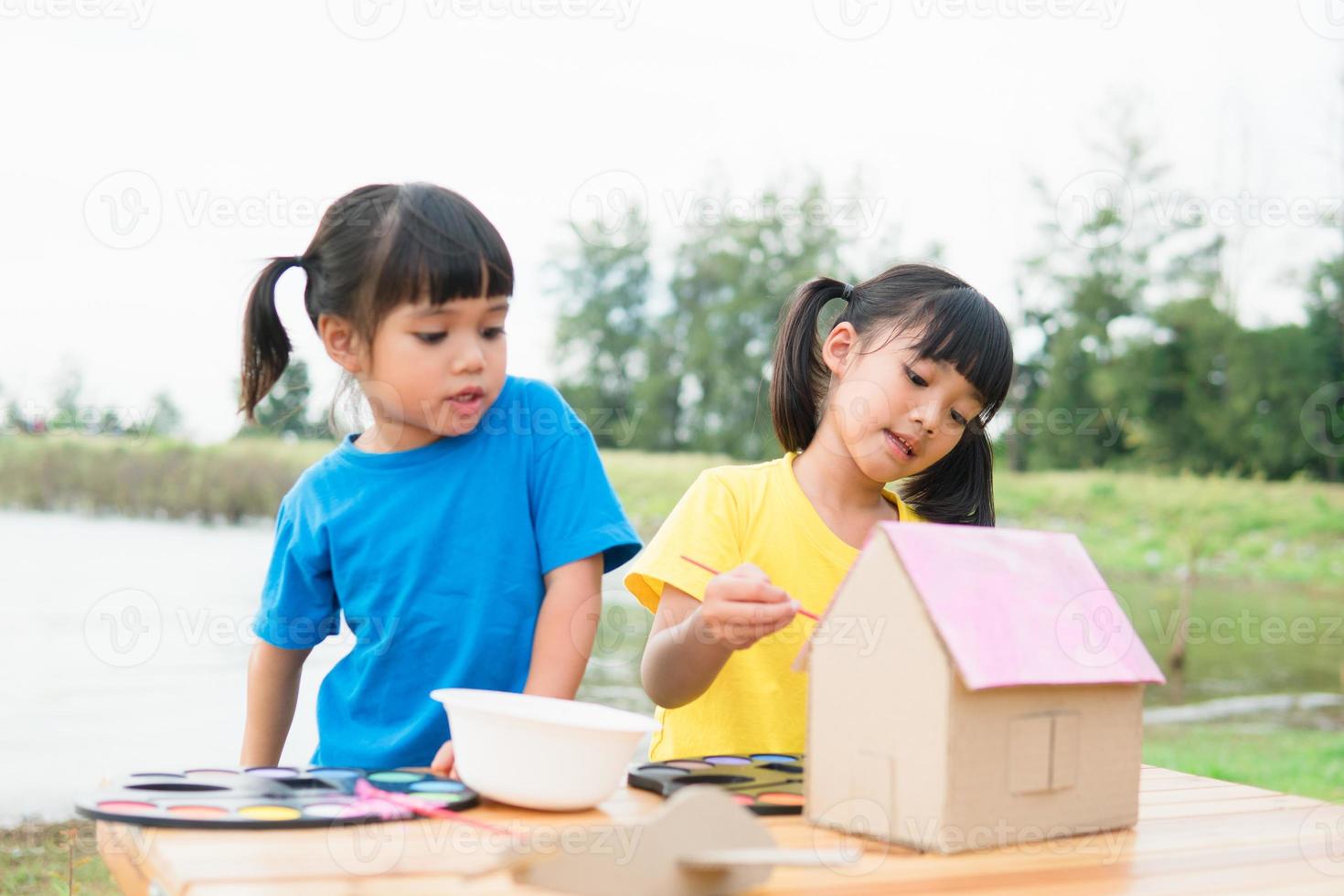 Asian sibling children drawing and painting colouring on the paper photo