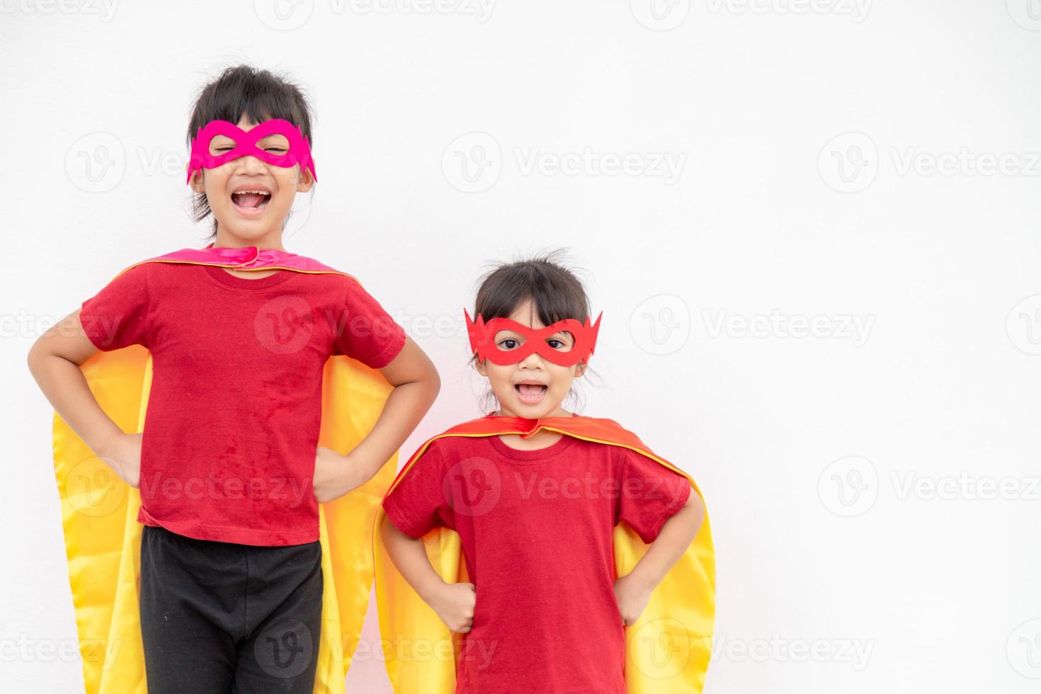 dos niñas en un traje de superhéroe sobre fondo blanco foto