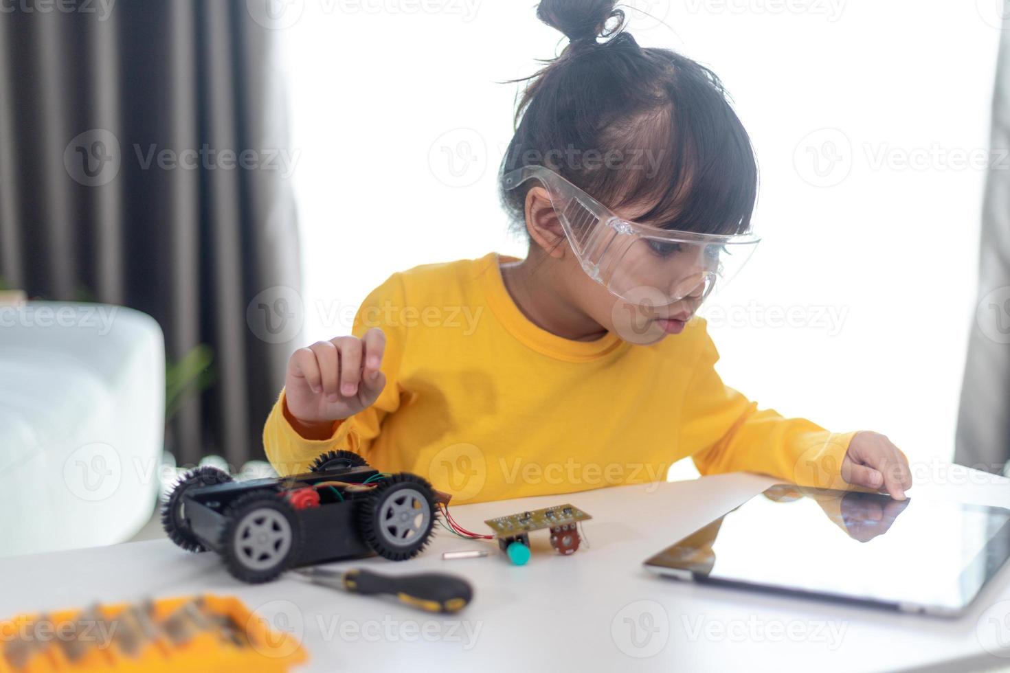 Inventive kid constructing robot cars at home photo