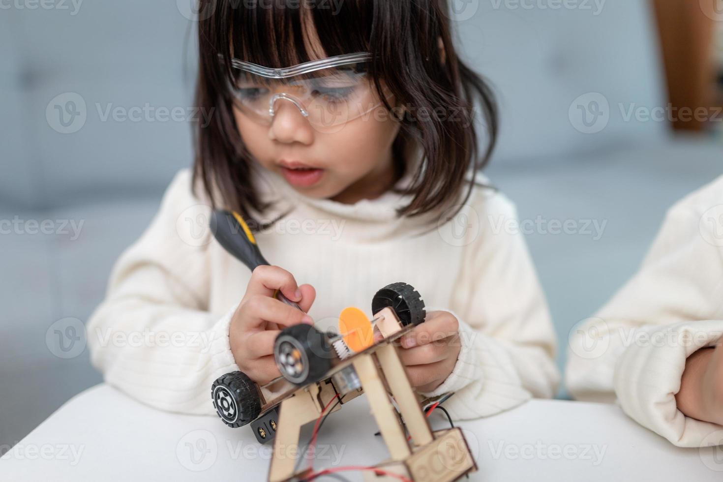 Inventive kid constructing robot cars at home photo