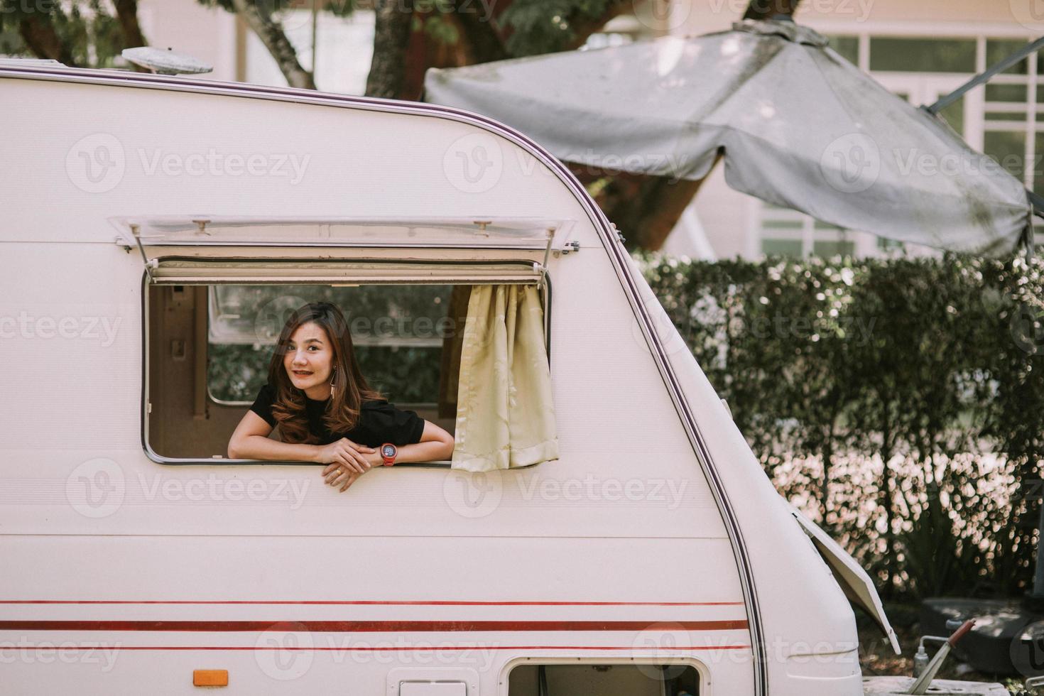 Happy beautiful pretty asian woman by motorhome window photo