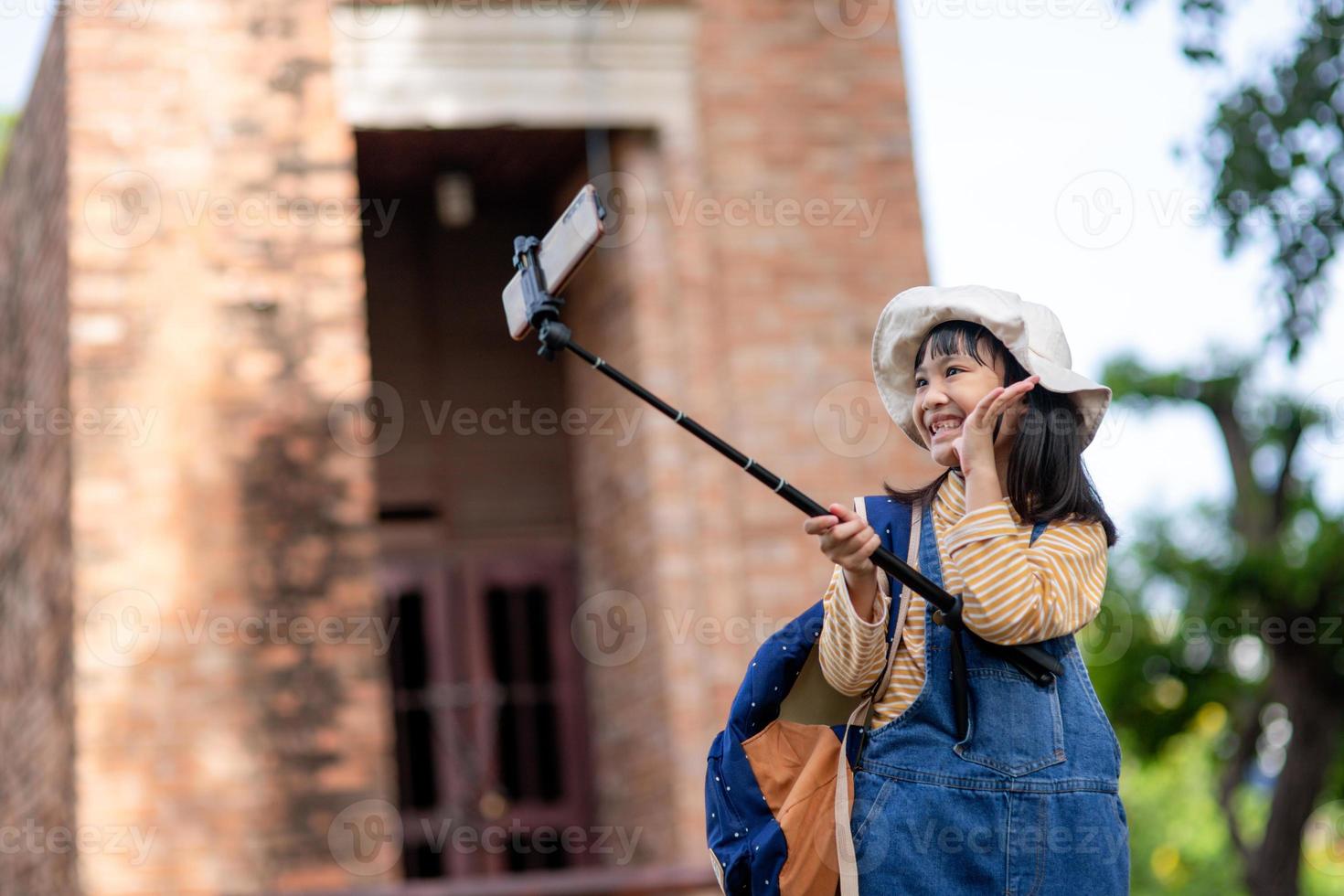 Happy Asian traveler girl takes a photo with a smartphone camera.