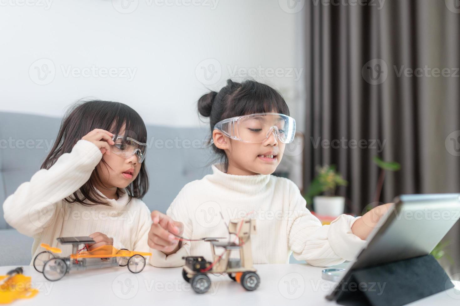 Inventive kid constructing robot cars at home photo