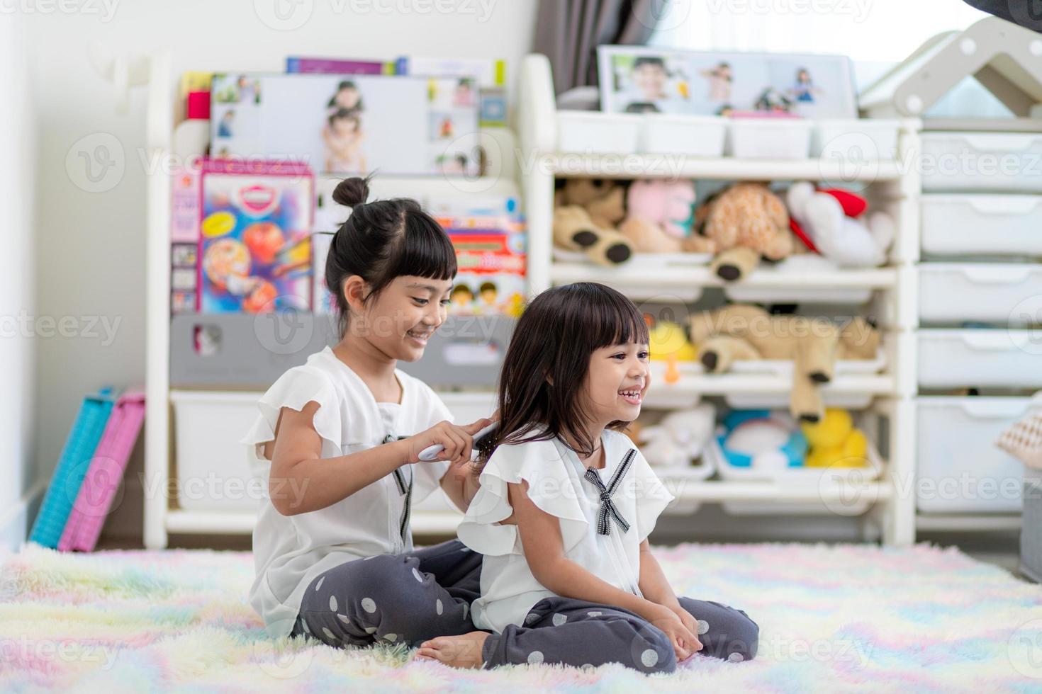 Cute little children playing while sitting on carpet at home photo