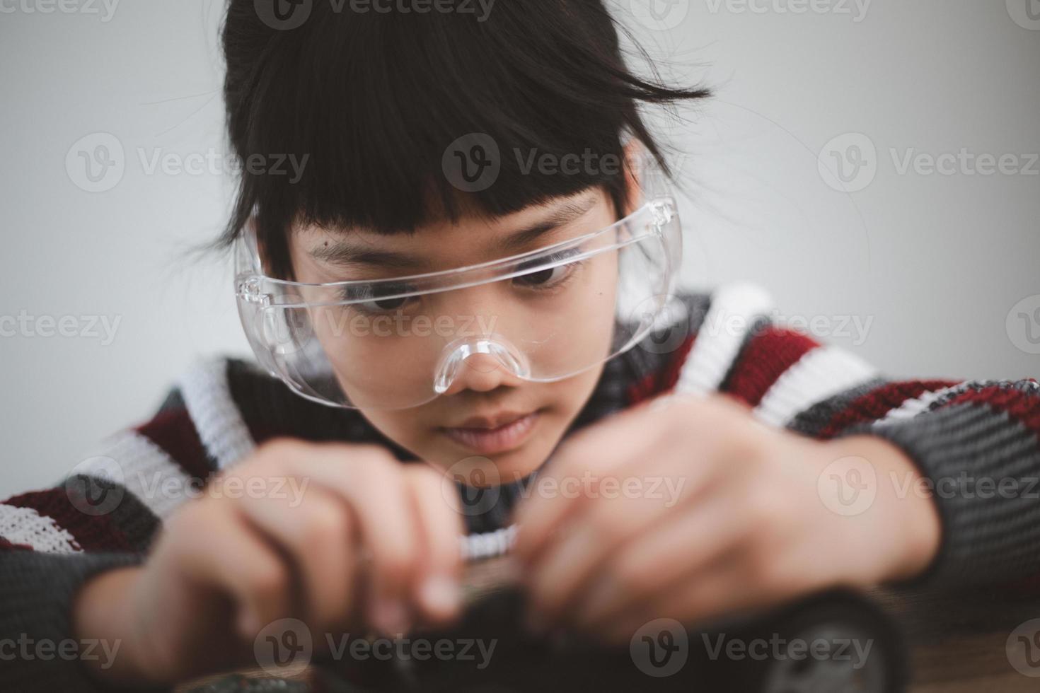 niño ingenioso construyendo autos robot en casa foto