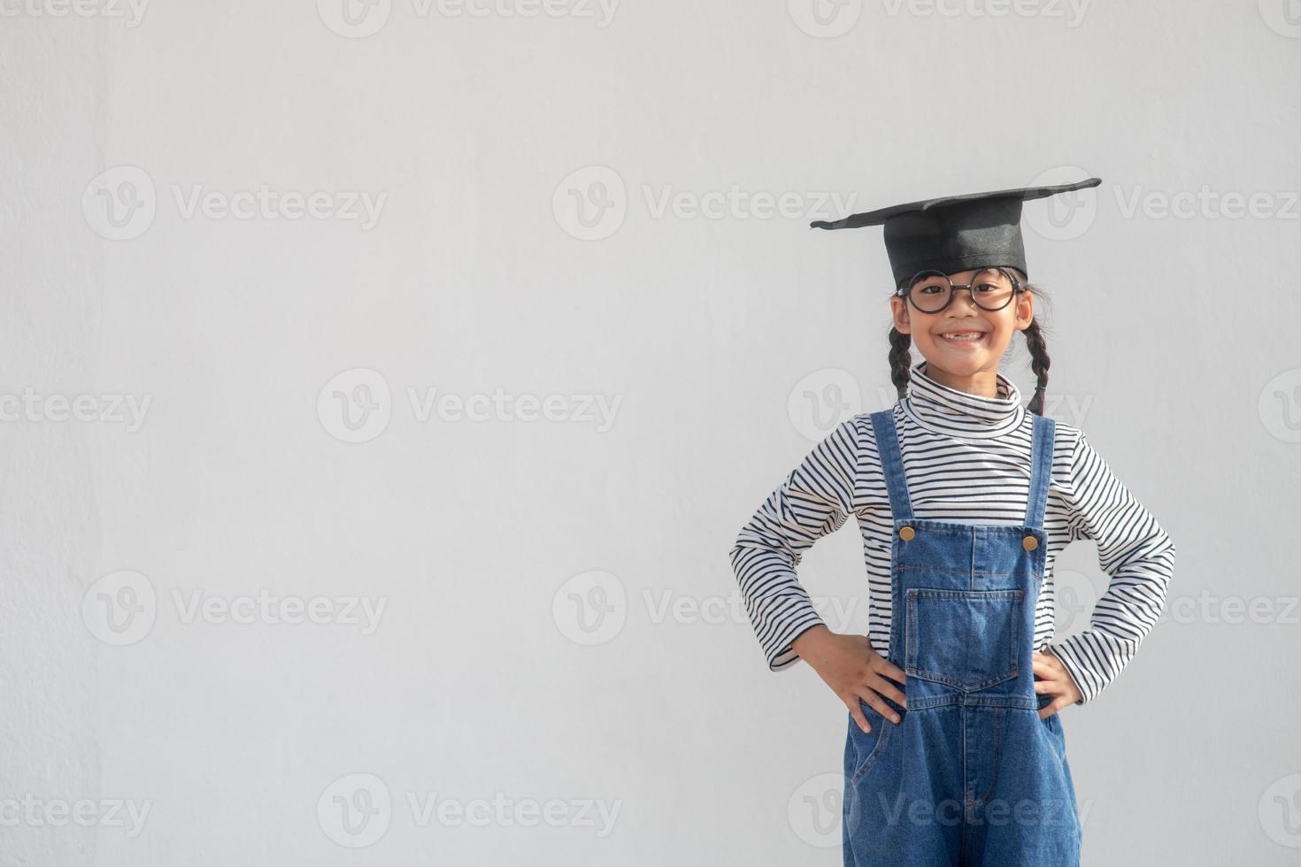 Happy Asian school kid graduate in graduation cap photo