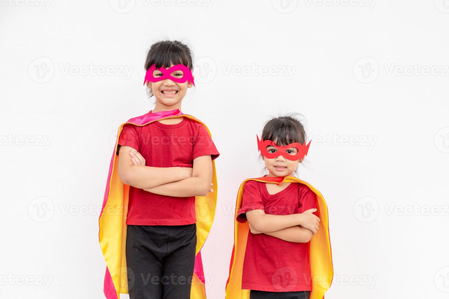 dos niñas en un traje de superhéroe sobre fondo blanco foto