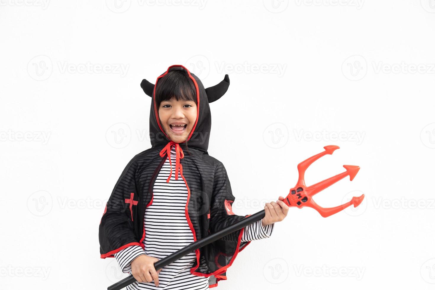 niña asiática disfrazada de demonio con tridente negro y rojo, feliz concepto de halloween foto