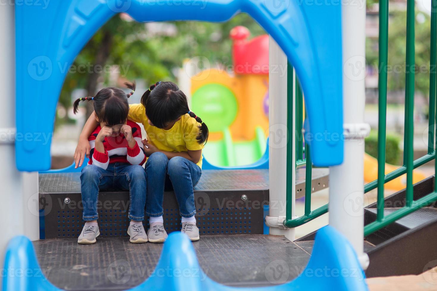 little girl comforting her sister at playground photo
