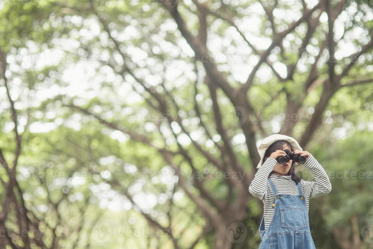 Happy kid looking ahead. Smiling child with the binoculars. Travel and adventure concept. Freedom, vacation photo