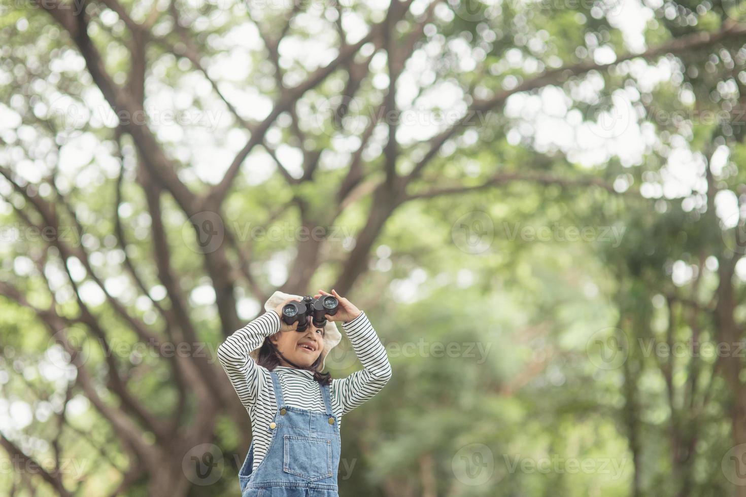 Happy kid looking ahead. Smiling child with the binoculars. Travel and adventure concept. Freedom, vacation photo