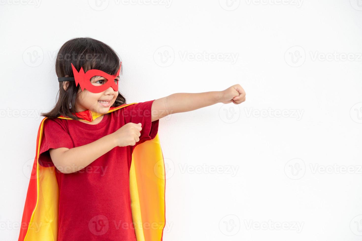 concepto de niños, niña sonriente jugando superhéroe sobre fondo blanco foto