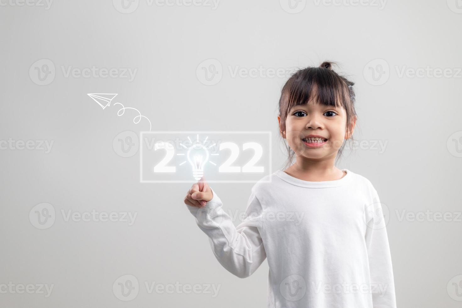 Happy cute little kids smiling and touching 2022 numbers isolated on white background for new year concepts photo