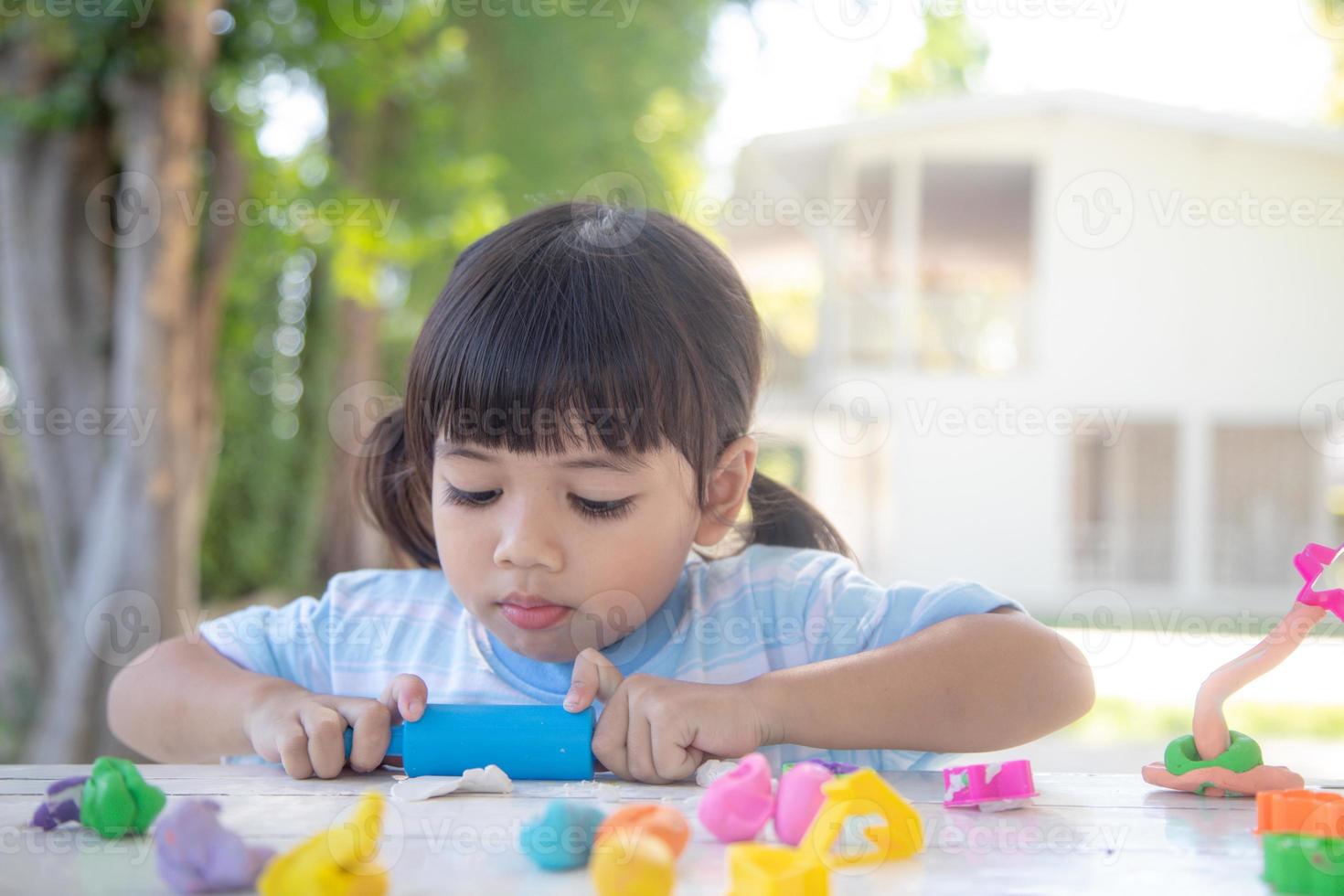 los niños asiáticos juegan con formas de moldeo de arcilla, aprendiendo a través del juego foto