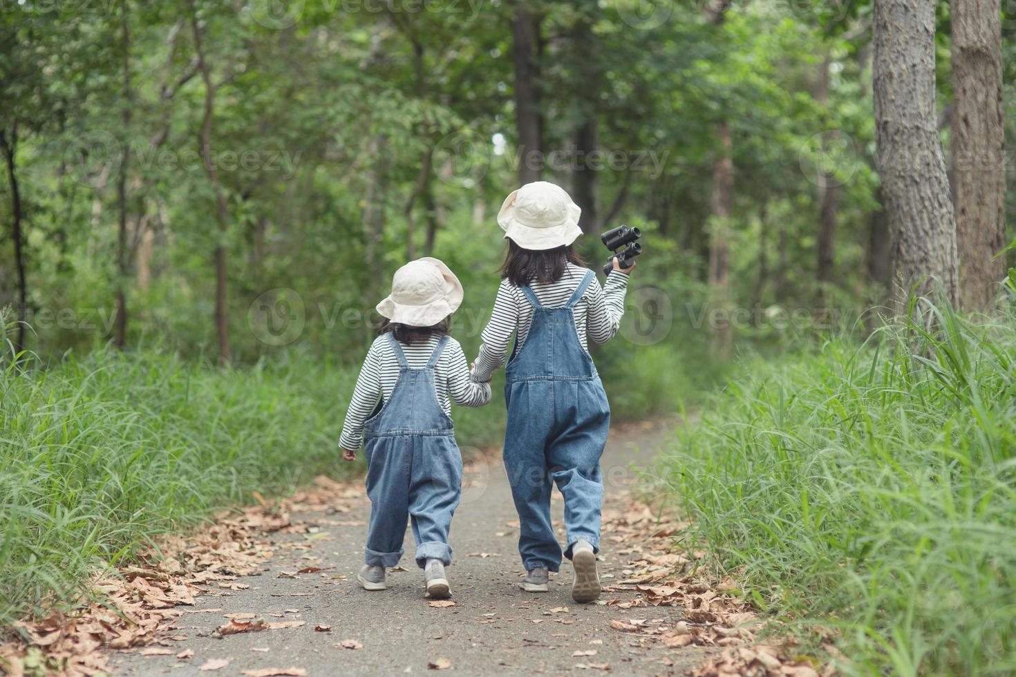 Children are heading to the family campsite in the forest Walk along the tourist route. Camping road. Family travel vacation concept. photo