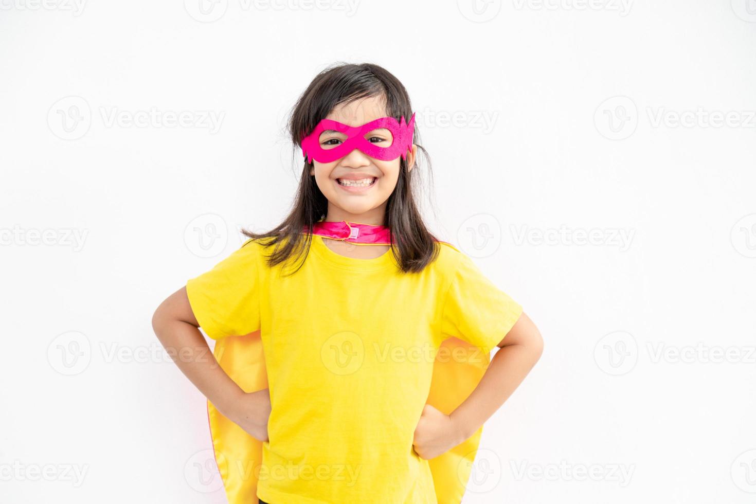 Funny little girl playing power super hero over white background. Superhero concept. photo