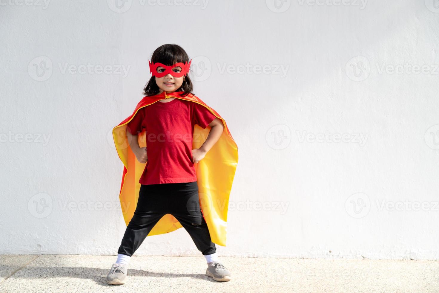 concepto de niños, niña sonriente jugando superhéroe sobre fondo blanco foto