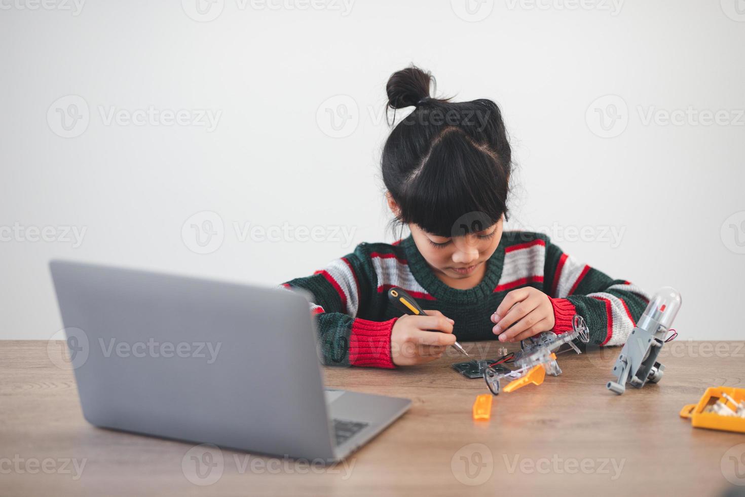 Inventive kid constructing robot cars at home photo