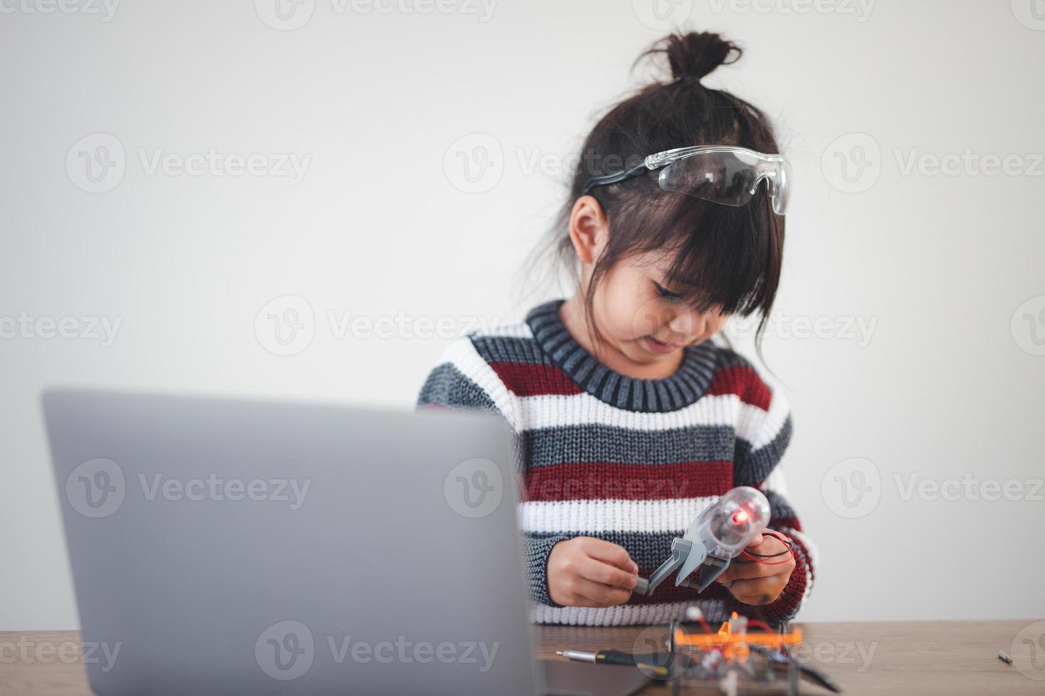Inventive kid constructing robot cars at home photo