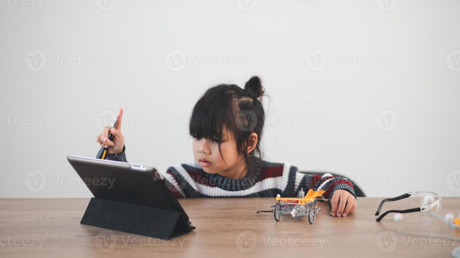Inventive kid constructing robot cars at home photo