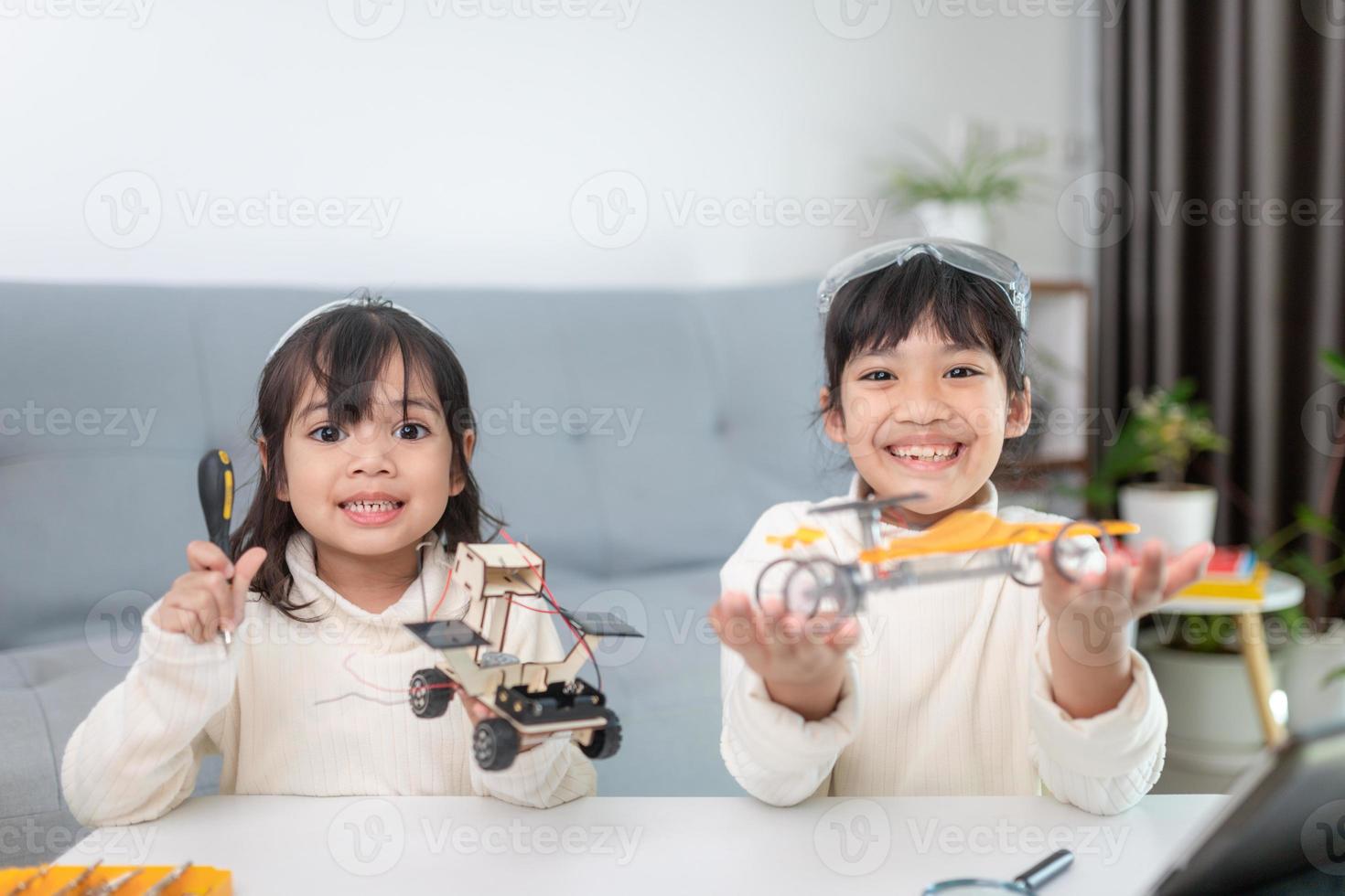 Inventive kid constructing robot cars at home photo