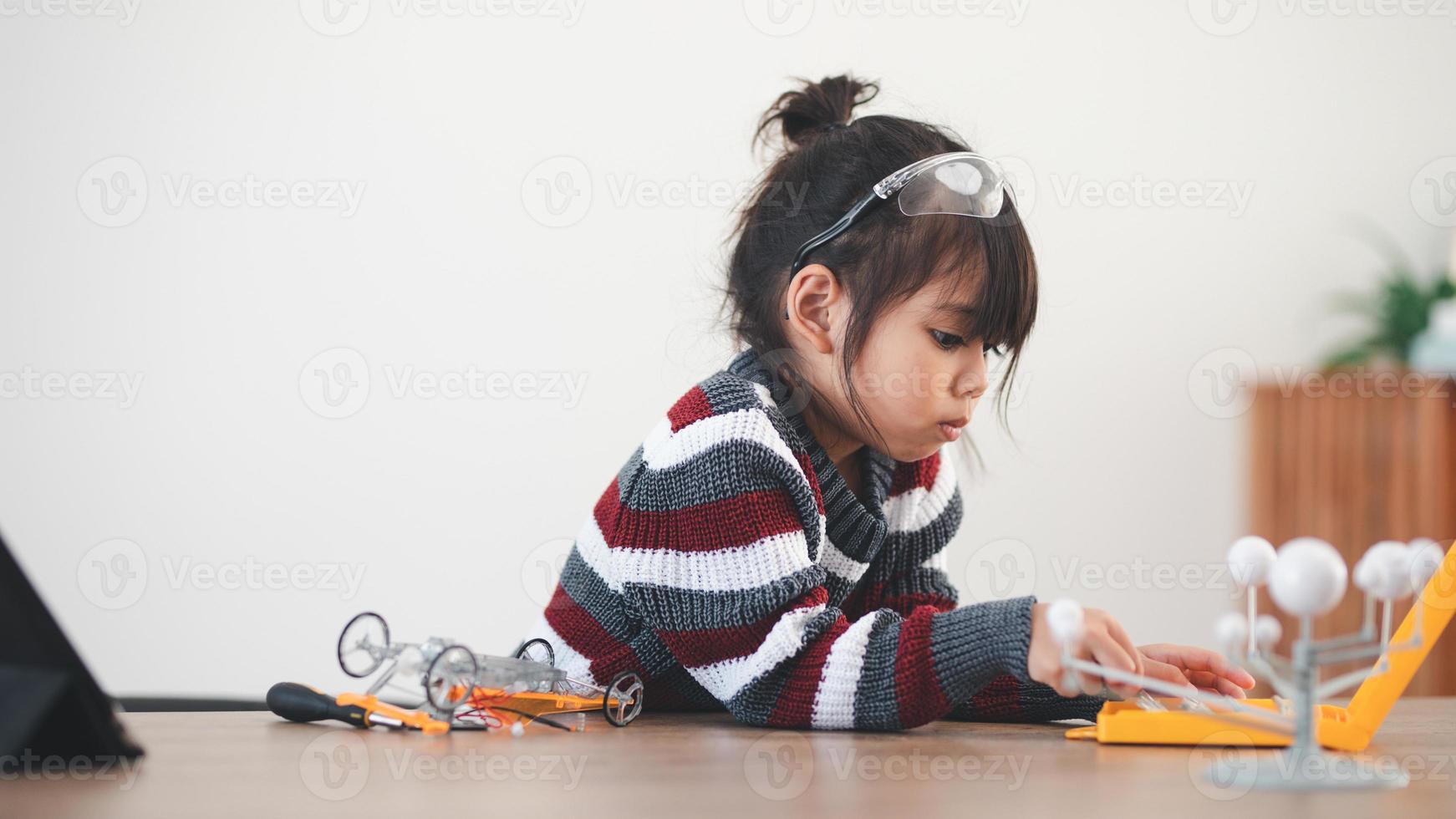 Inventive kid constructing robot cars at home photo