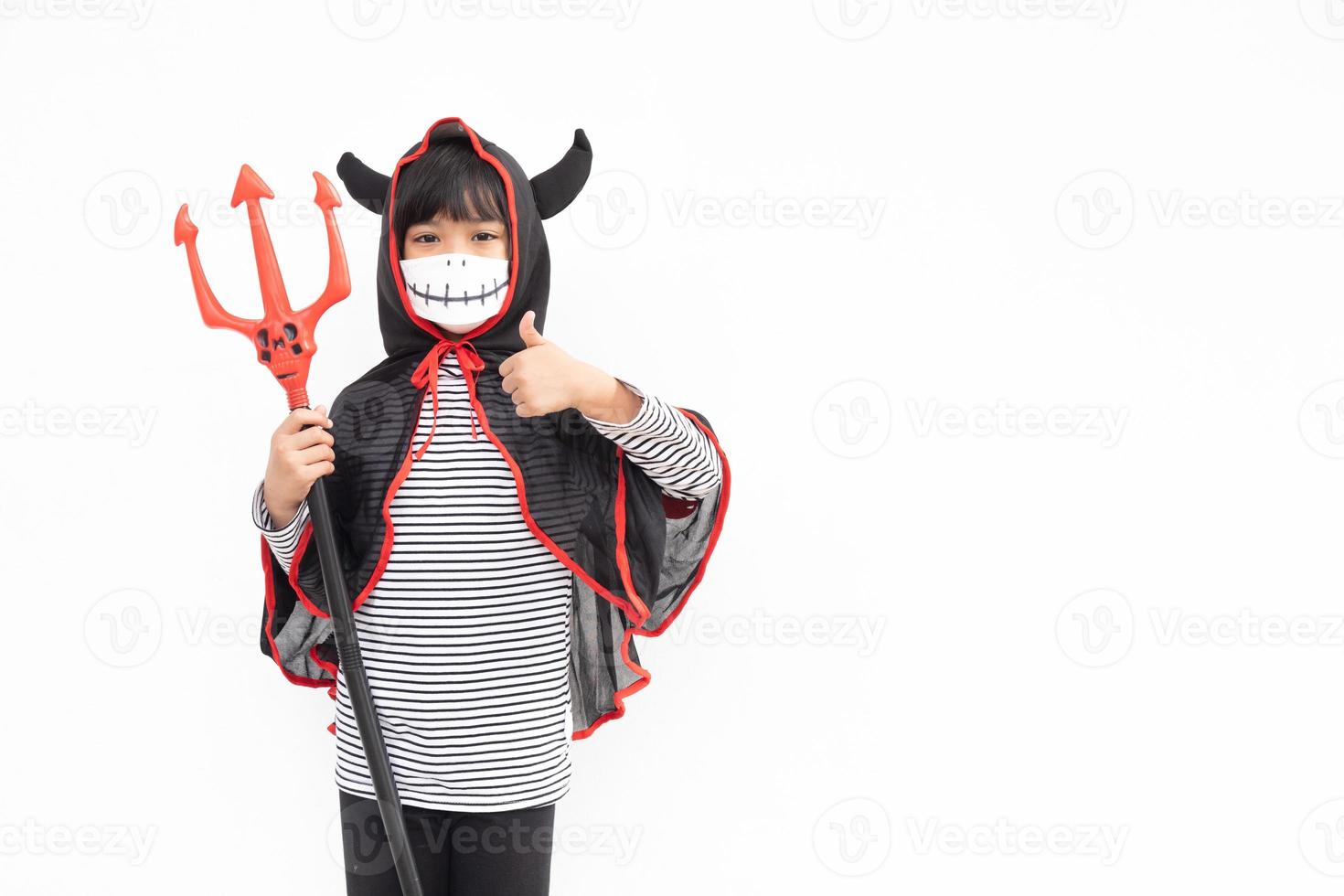 Asian little girl in a Halloween costume in a medical mask . Halloween with safety measures from Covid-19 photo