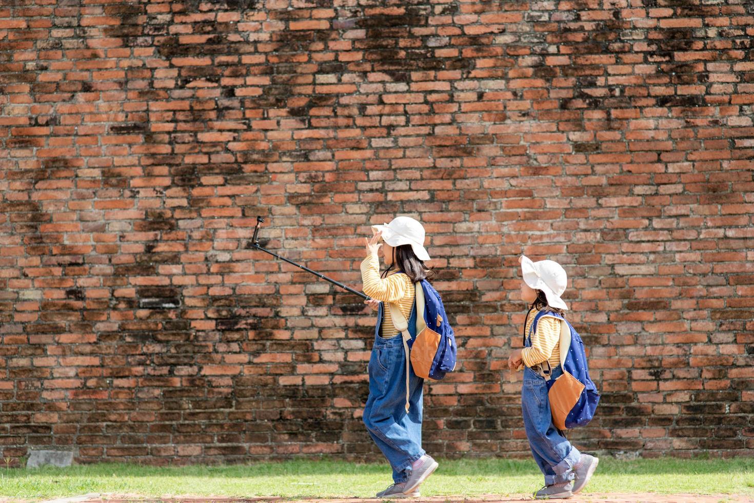 Two Asian children girls are bloggers. Broadcast on the Internet. Record vlog and blog subscribers. Record video lessons for Internet. Use camera with tripod. photo