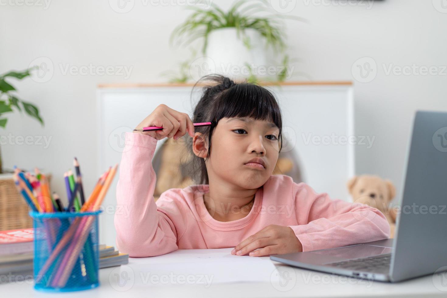 Unhappy little Caucasian girl child sit at table at home feel lazy unmotivated doing homework assignment. Upset distressed small 7s kid prepare school task, learn study with books. Education concept. photo