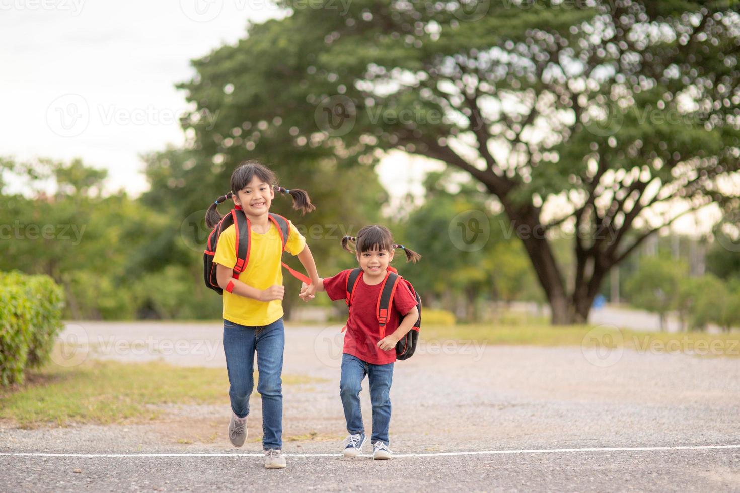 Cute Asian children holding hand together while going to the school photo