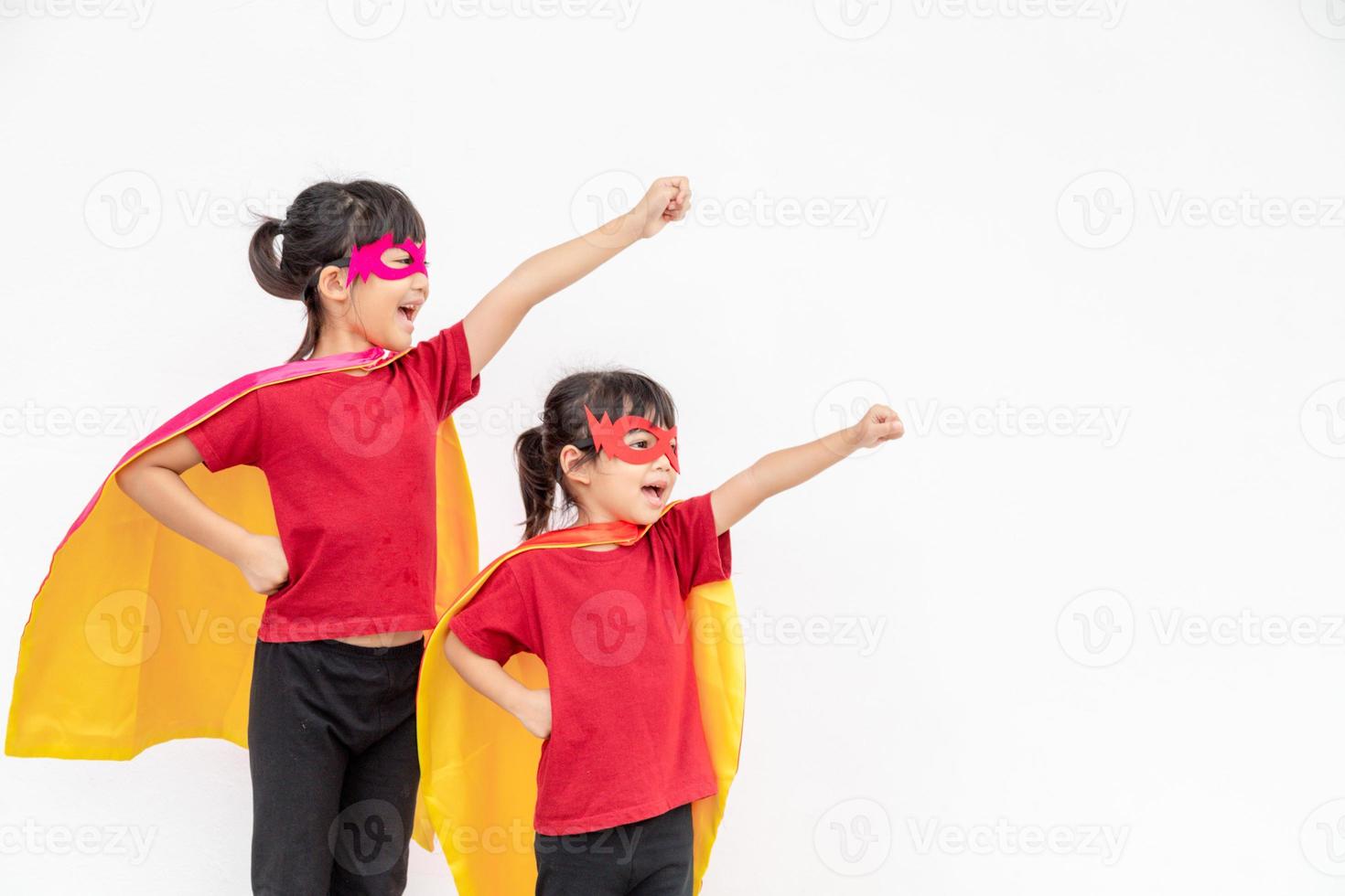 Two girls in a superhero costume on white background photo