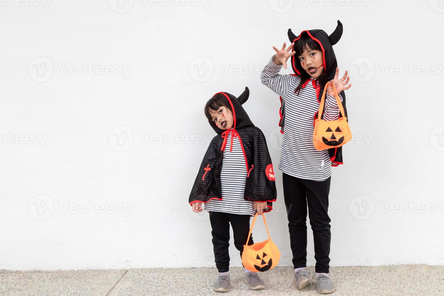 happy Halloween two children in Halloween costumes and with pumpkins on white background photo