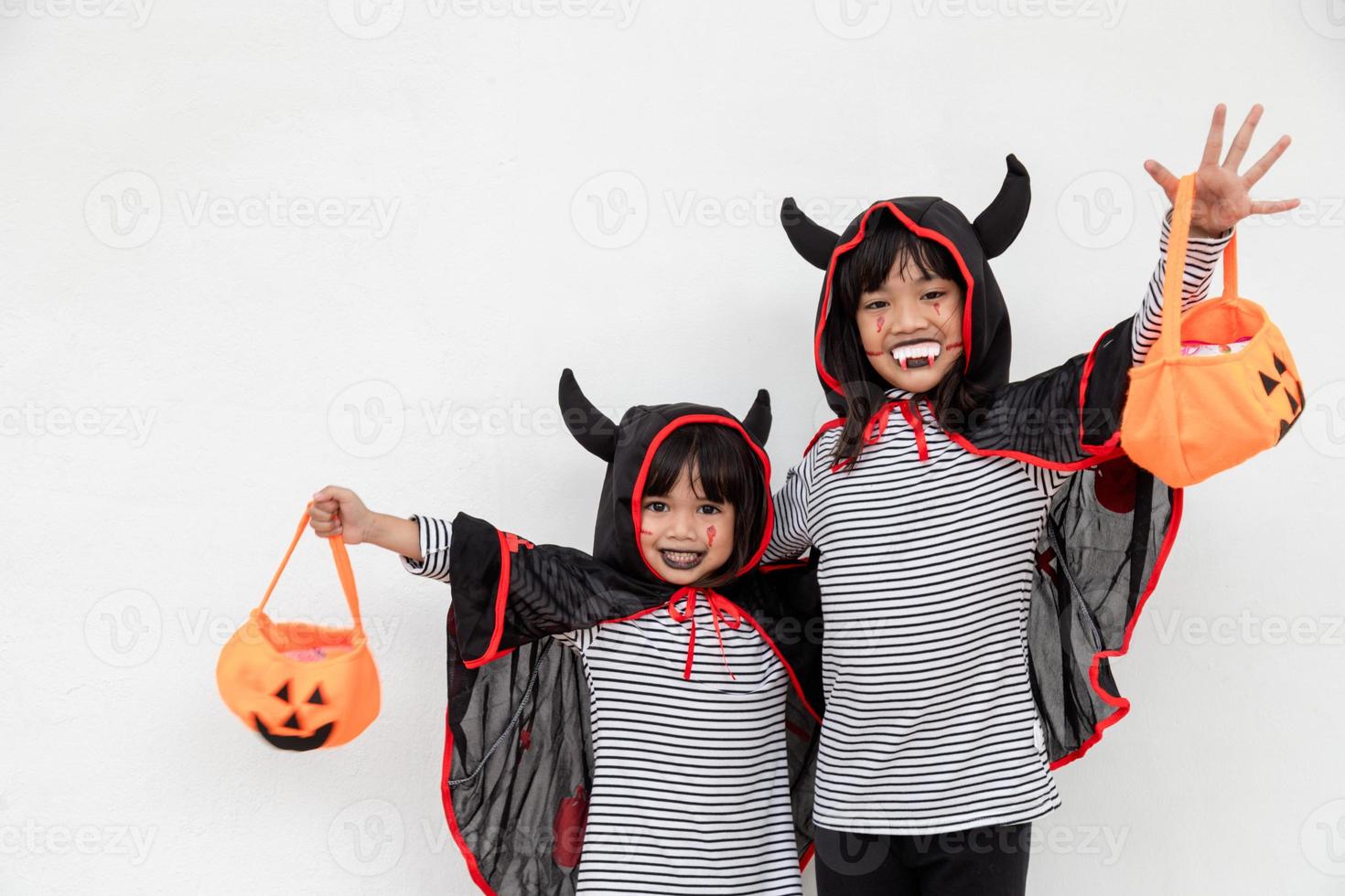 happy Halloween two children in Halloween costumes and with pumpkins on white background photo