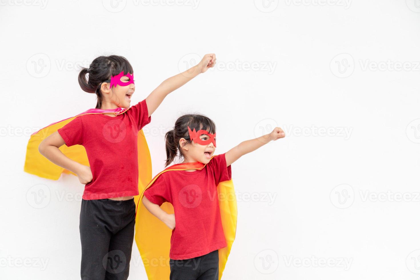 dos niñas en un traje de superhéroe sobre fondo blanco foto