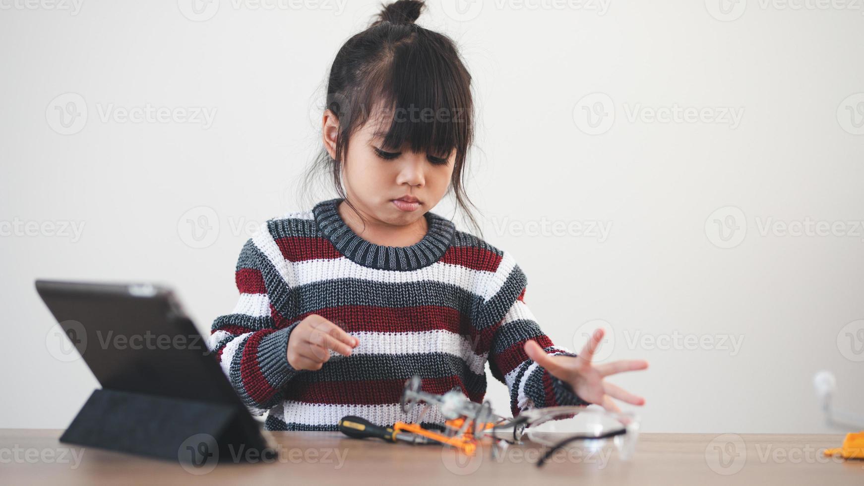 Inventive kid constructing robot cars at home photo