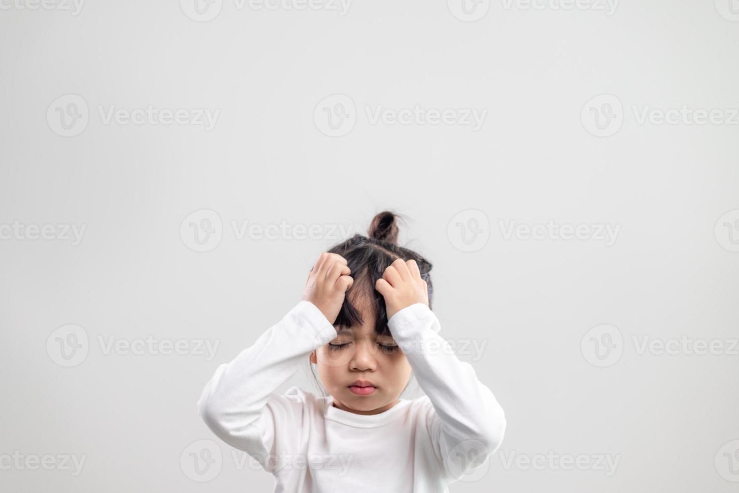 Sad little girl holds his head. little girl feeling sick, having headache. photo