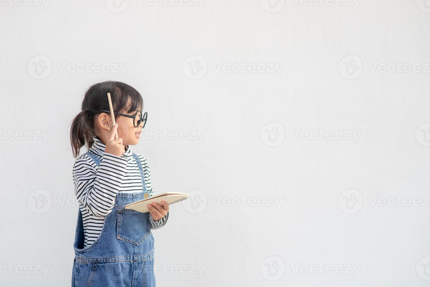 Cute Asian small girl wearing glasses and thinking photo