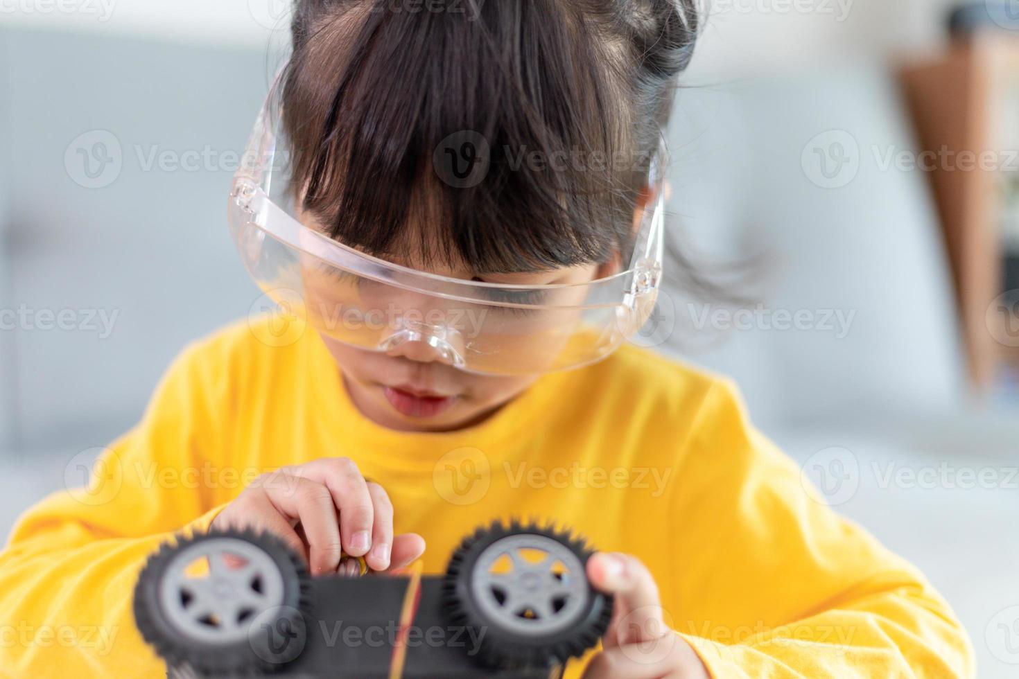 Inventive kid constructing robot cars at home photo