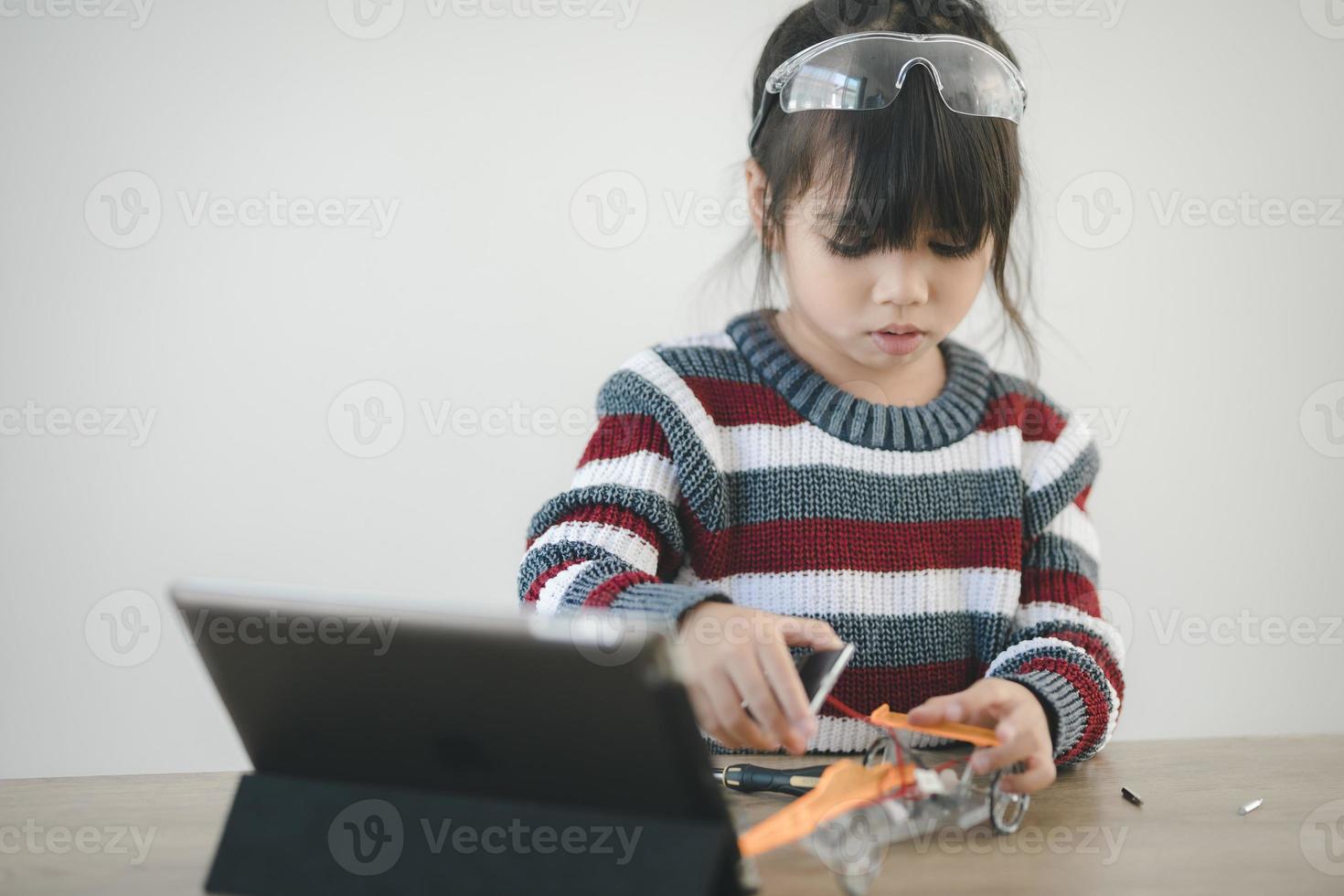 Inventive kid constructing robot cars at home photo