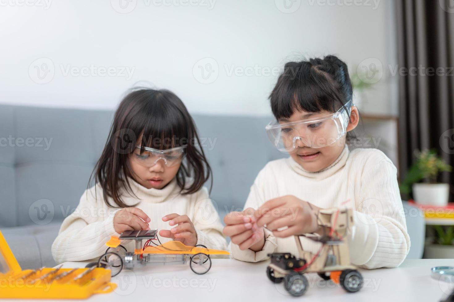 Inventive kid constructing robot cars at home photo