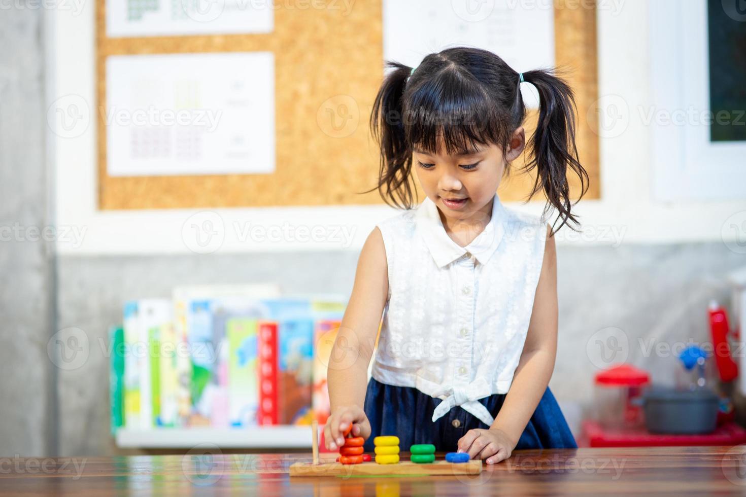 child little girl playing wooden toys photo