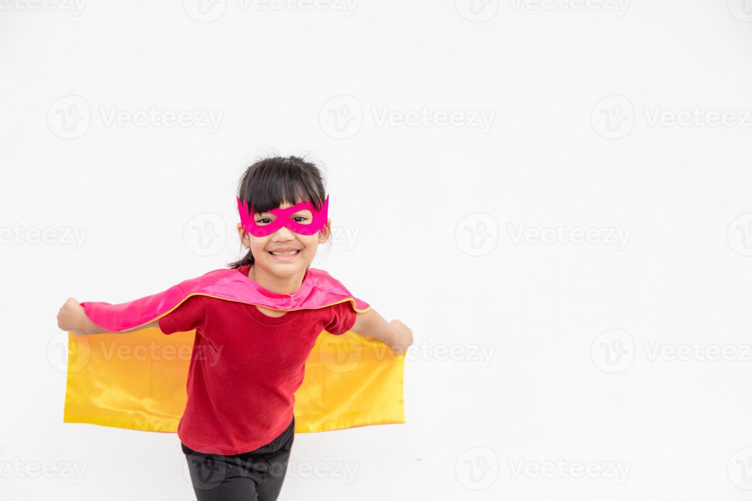 Funny little girl playing power superhero over white background. superhero concept. photo